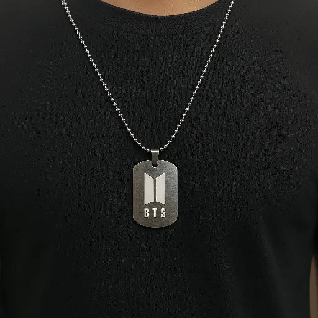 Dog tag necklace with BTS logo on a black shirt