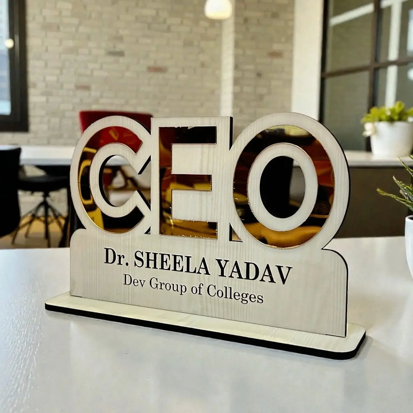 Wooden nameplate with 'CEO' and personal details on a desk