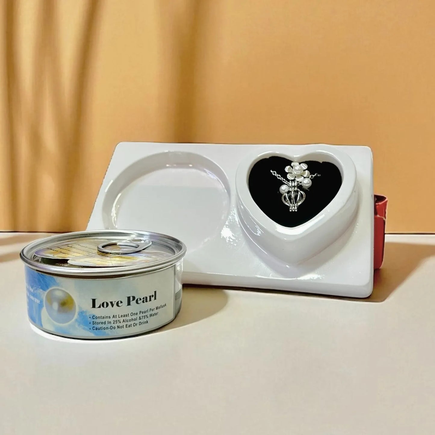 Canned pet food labeled 'Love Pearl' next to a heart-shaped dish on a beige background