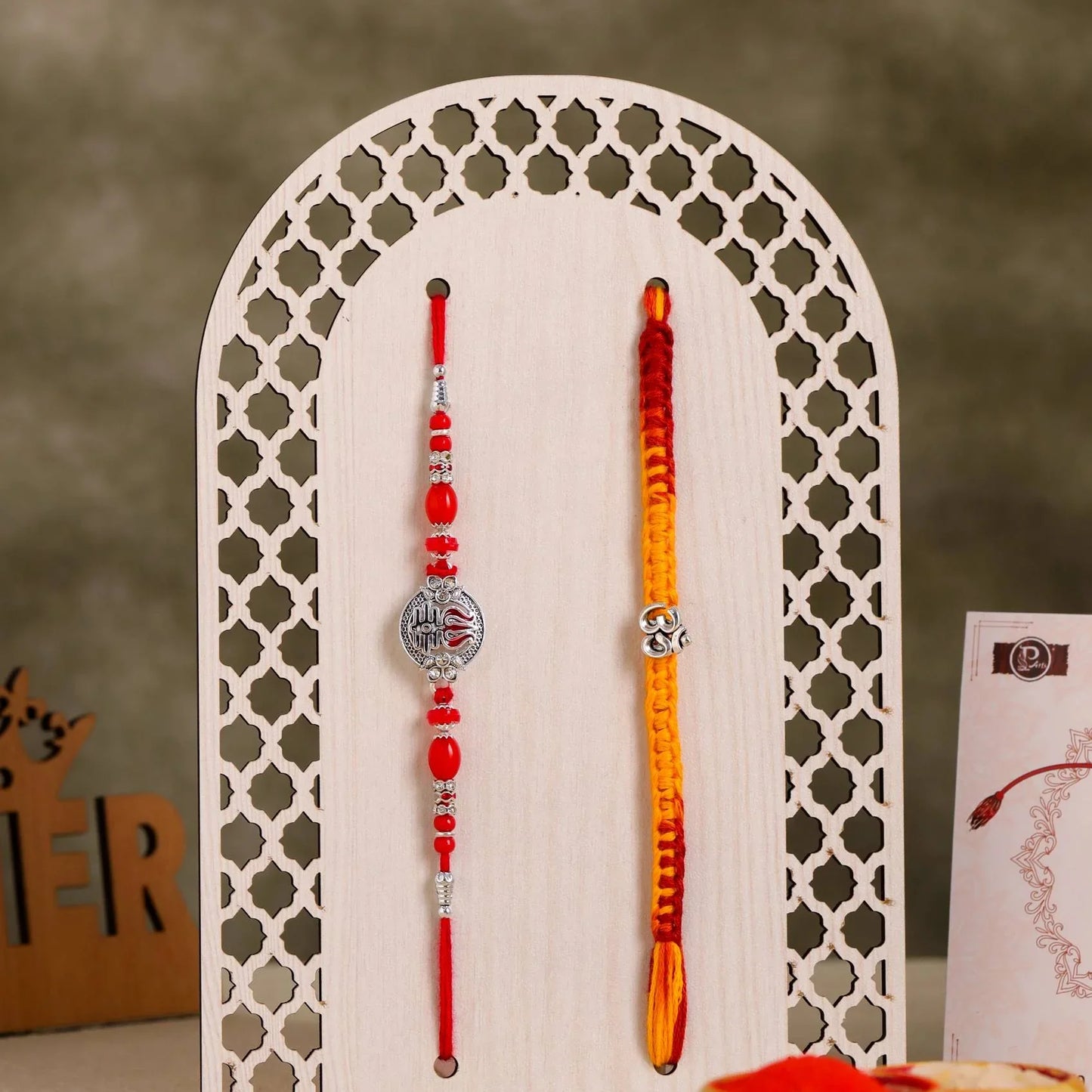 lose-up of Designer Rakhi Combo with Om and Red Stone Beads