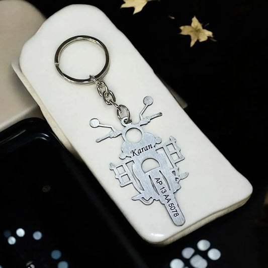 Keychain with motorcycle design and 'Karan' text on a white case.