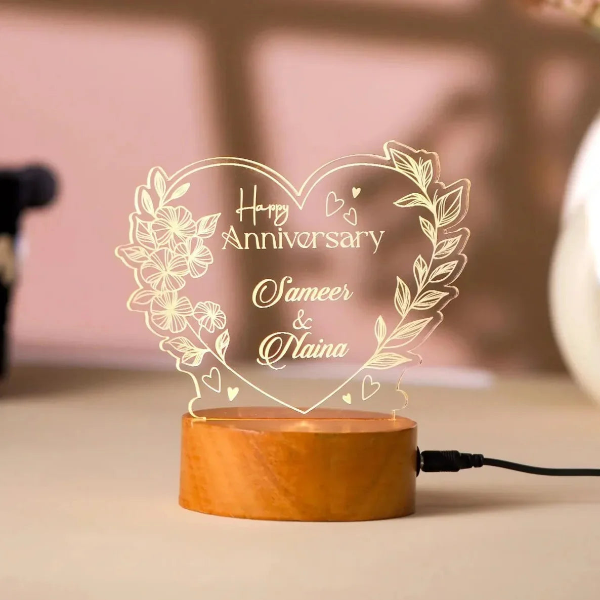 Decorative lamp with 'Happy Anniversary Sameer & Naina' text on a wooden base.