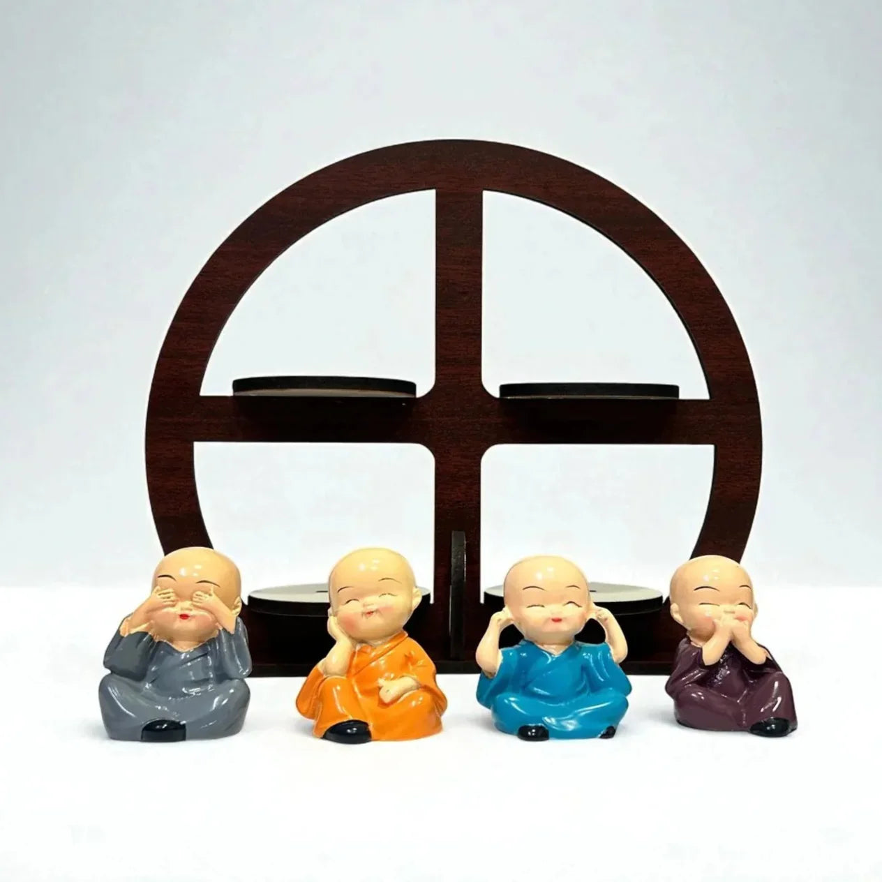 Four colorful monk figurines in front of a wooden arch on a white background