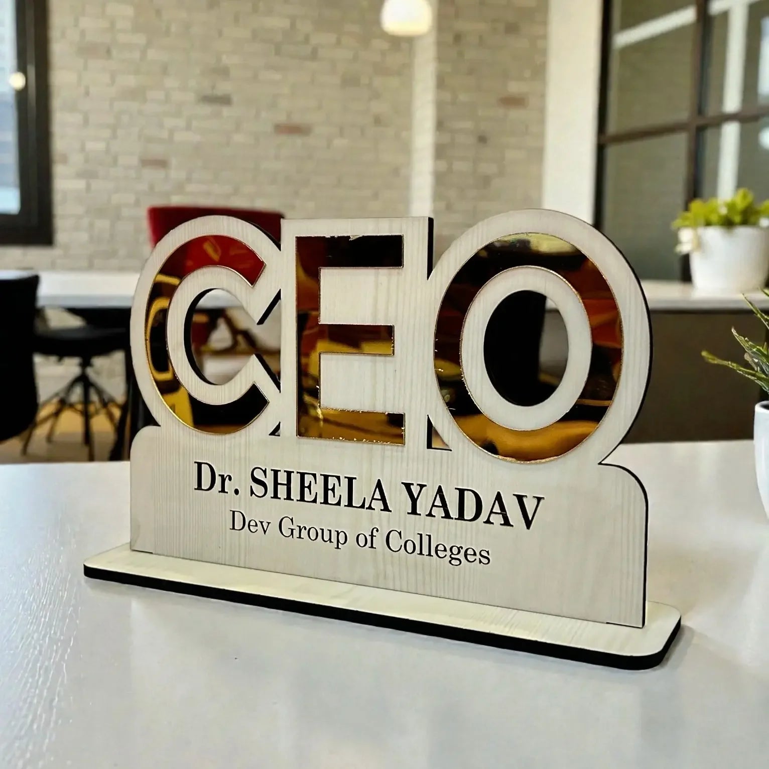 Wooden nameplate with 'CEO' and personal details on a desk