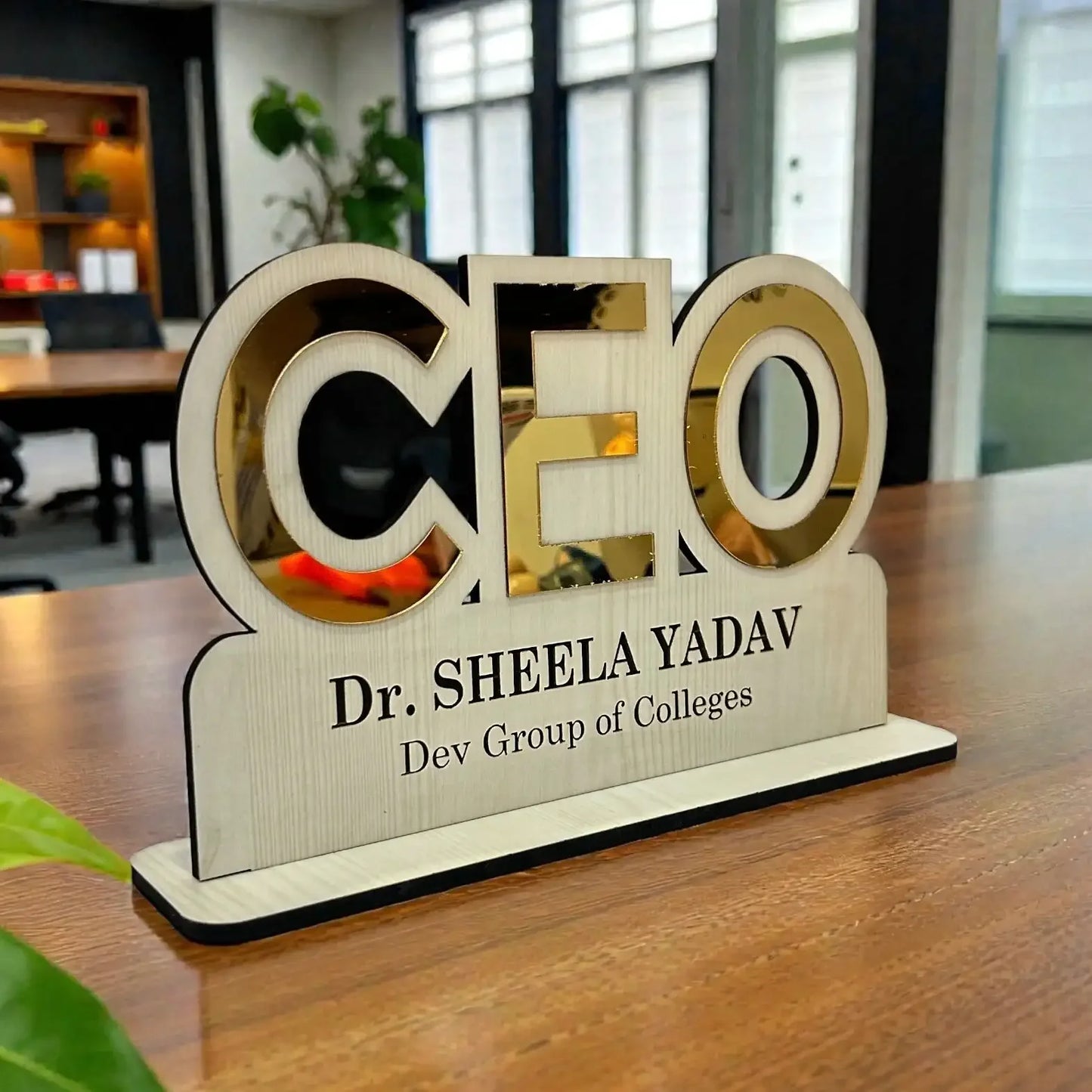 Decorative plaque with 'CEO' and personal name on a wooden stand in an office setting