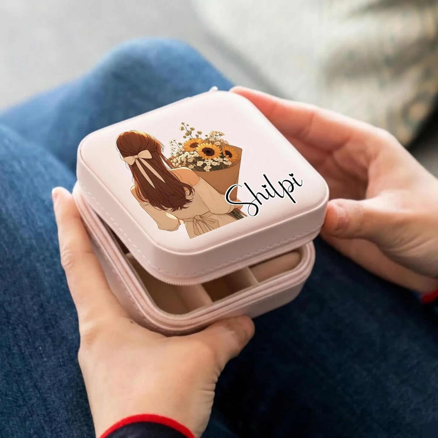 Person holding a pink jewelry box with an illustration and the name 'Shilpi' on it.