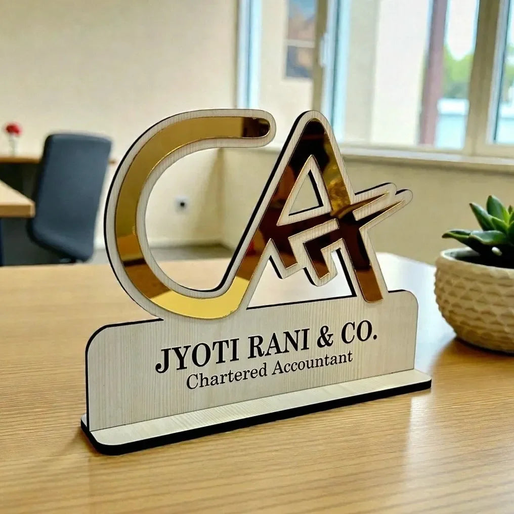 Decorative desk sign with 'CA' initials and 'Jyoti Rani & Co.' branding on a wooden surface.