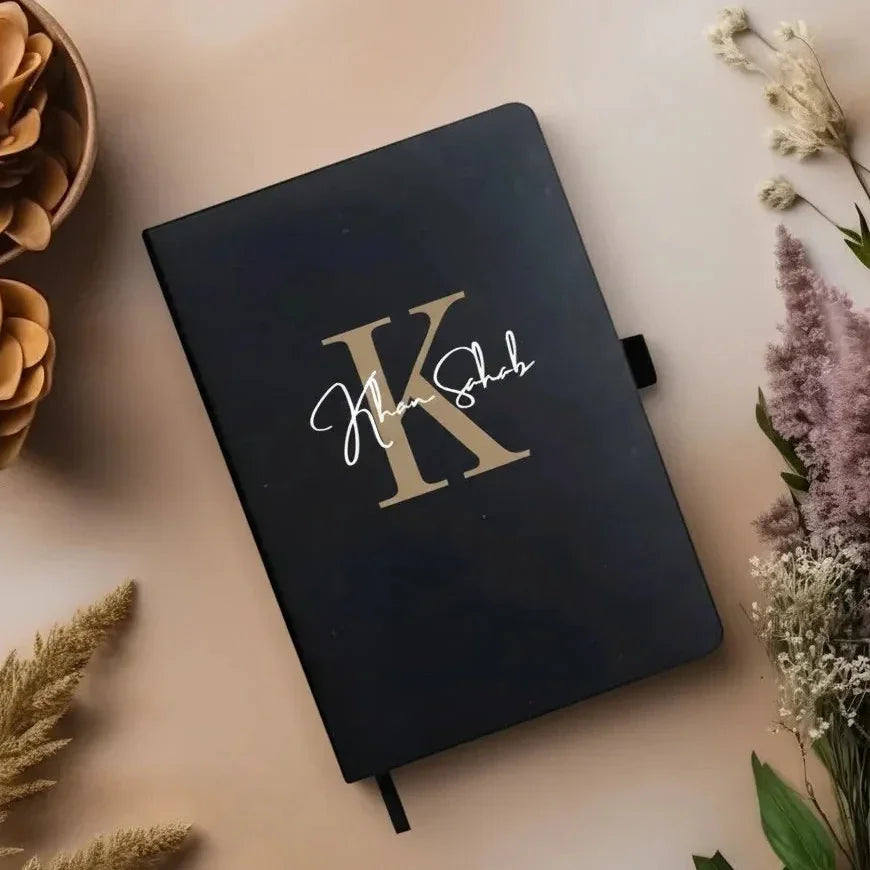 Black personalized diary with gold initial K and custom name on floral background