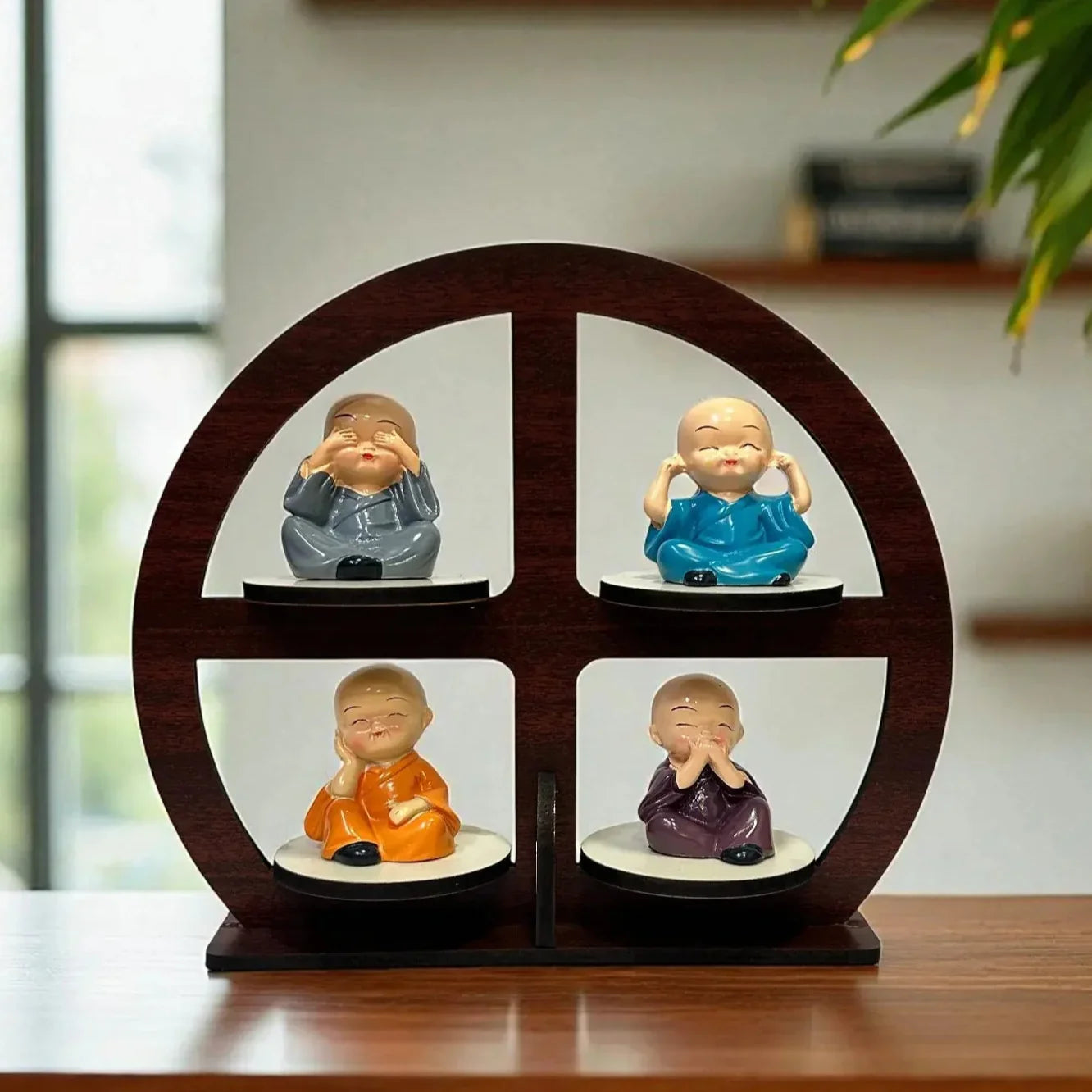 Decorative set of four small figurines on a wooden display stand with a blurred indoor background.