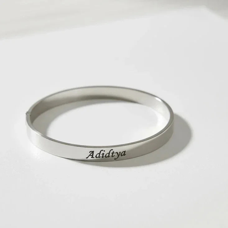 Silver bracelet with 'Aditiya' engraving on a light gray background
