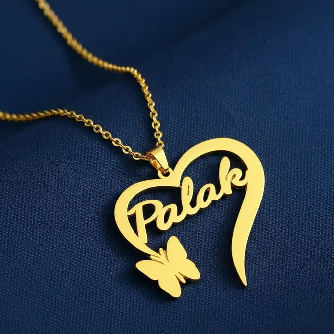 Gold heart-shaped necklace with 'Palak' and a butterfly on a blue background