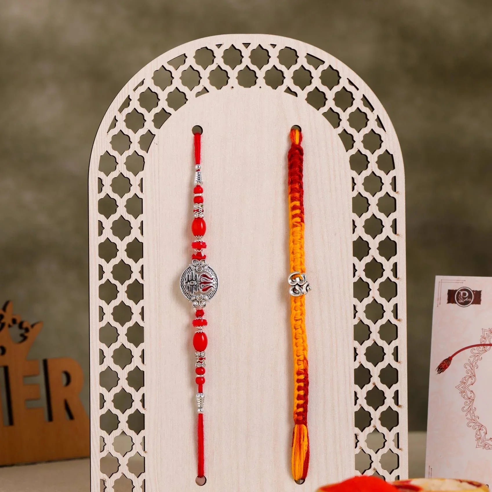 lose-up of Designer Rakhi Combo with Om and Red Stone Beads